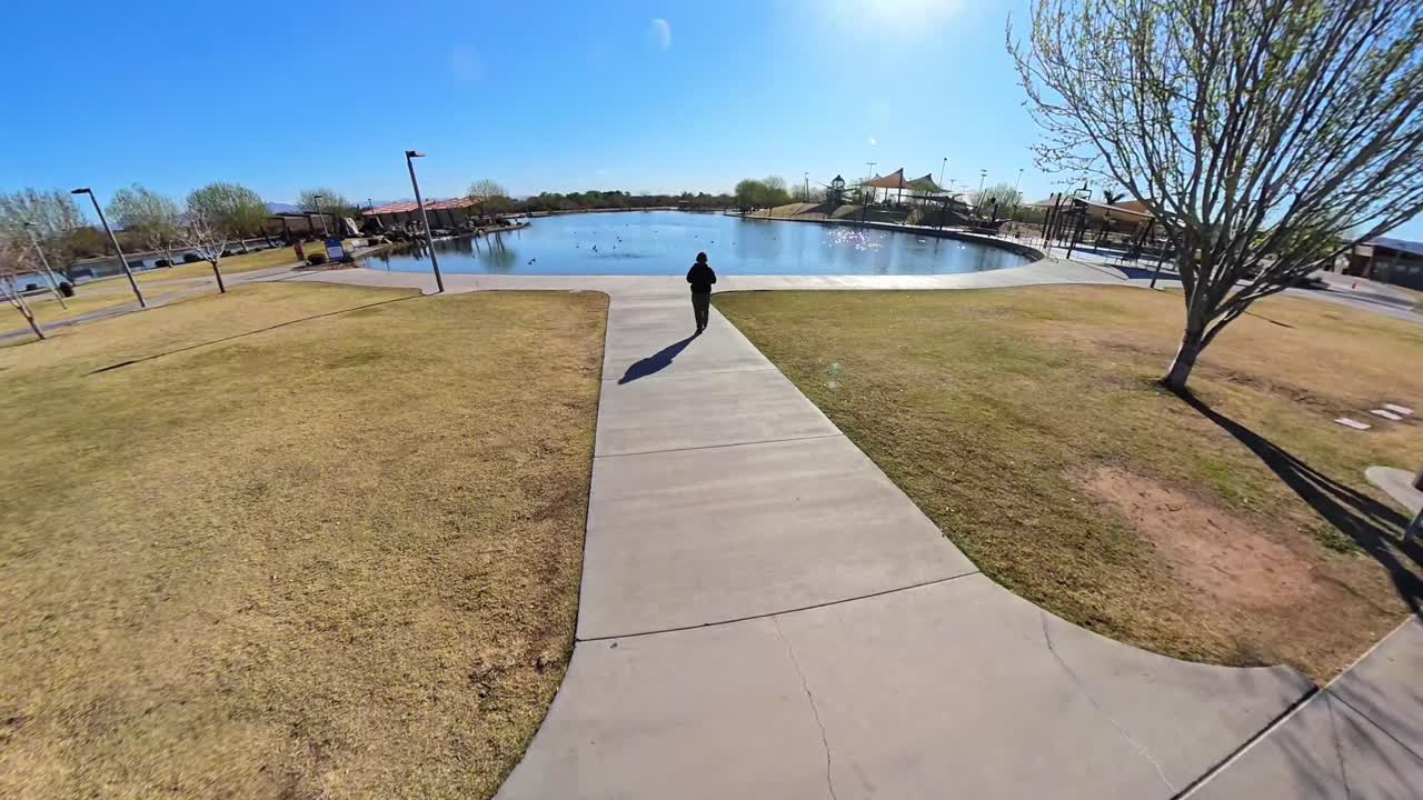 Red haired male walking to a lake in Mansel Crater Park in Queen Creek Arizona.