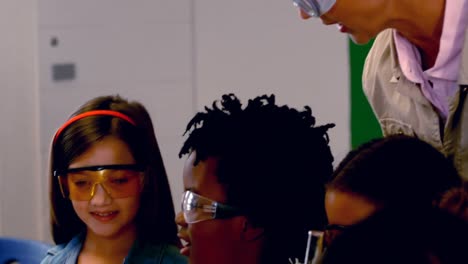 maestro ayudando a los niños en el laboratorio