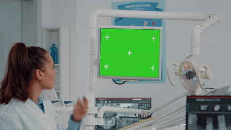 close up del dentista mirando el monitor con pantalla verde