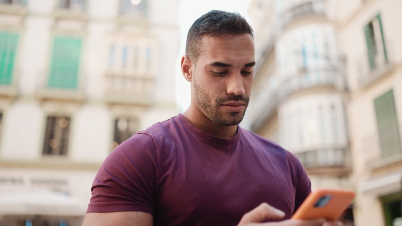 Young man checking smartphone outdoors.