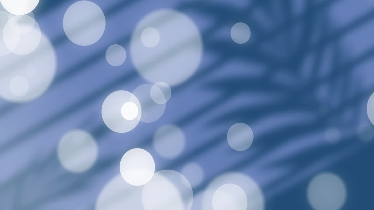 Animation of soft white bokeh circles over blurred blue background with shadows