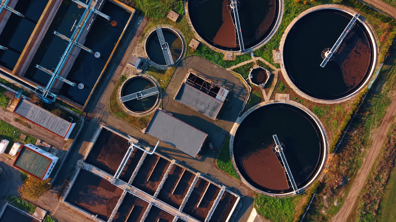 Waste dark water in the circle and rectangular reservoirs. Drone footage over the sewage recycling plant