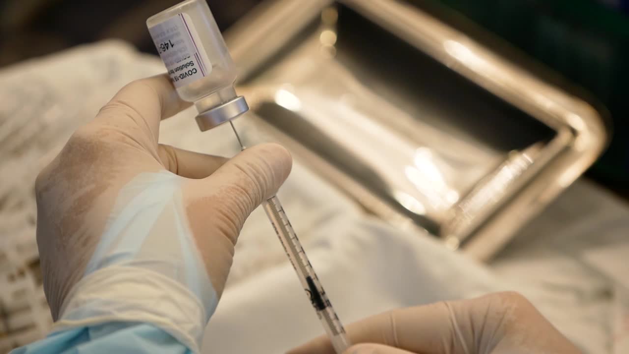 주사기를 사용하여 covid-19 백신 부스터를 꺼내는 간호사의 클로즈업 영상
