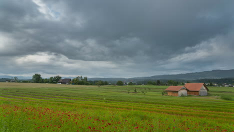 dark grey storm clouds move wall of rain across farmland fields in monchaltorf switzerland