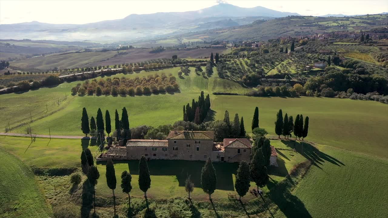 amazing landscape scenery of Tuscany in Italy - farmhouse, cypress trees along white road  - aerial view