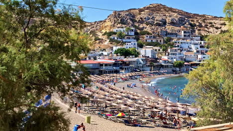 rethimno beach with beachfront accommodations and resorts in summer in greece. - wide shot