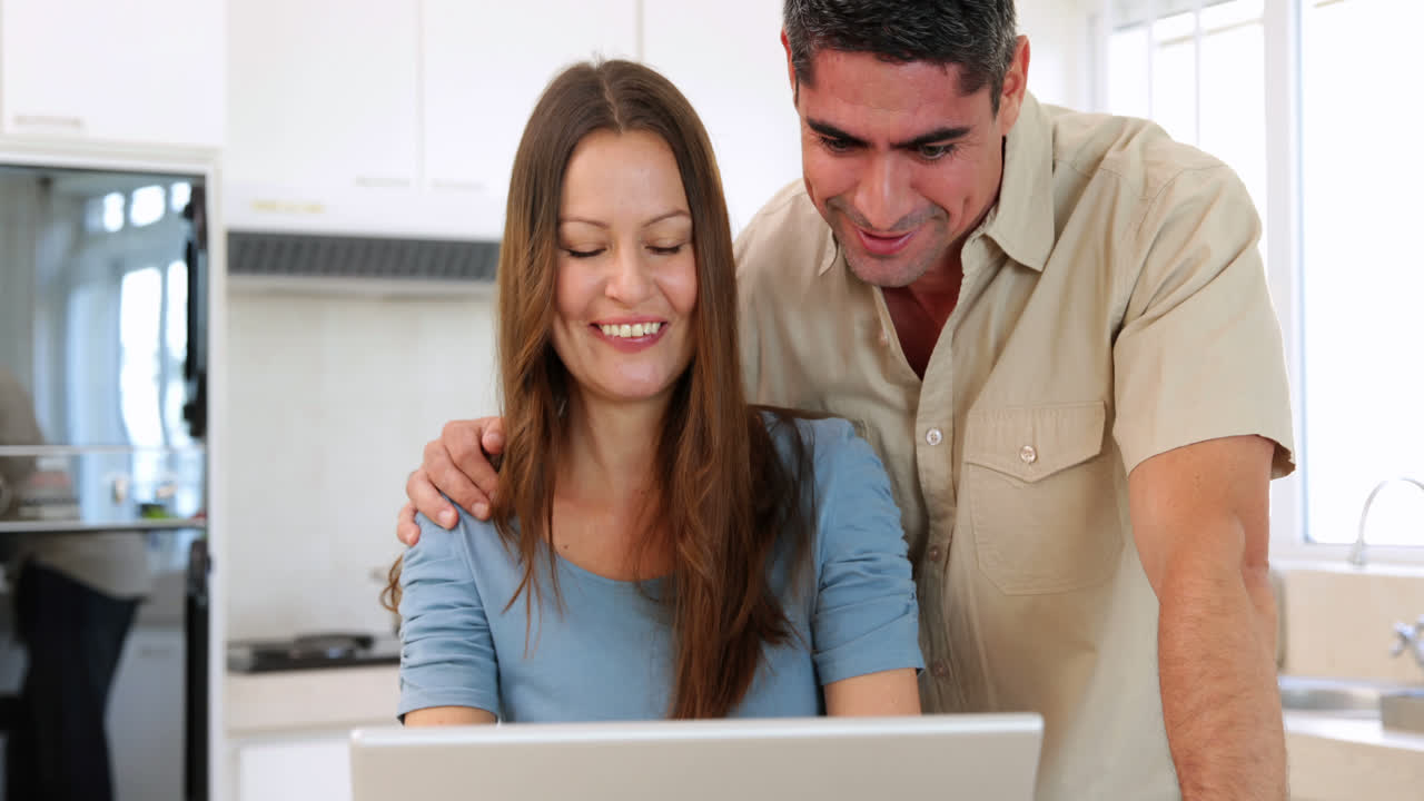 una pareja feliz mirando la computadora portátil