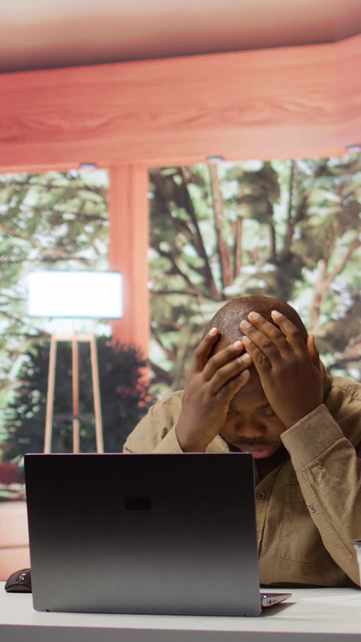 Stressed African American Man Working on Laptop in Office