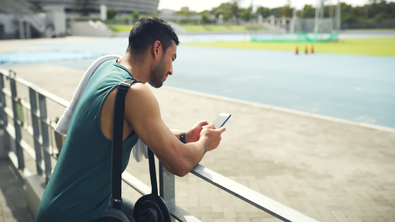 hombre usando teléfono inteligente en el estadio