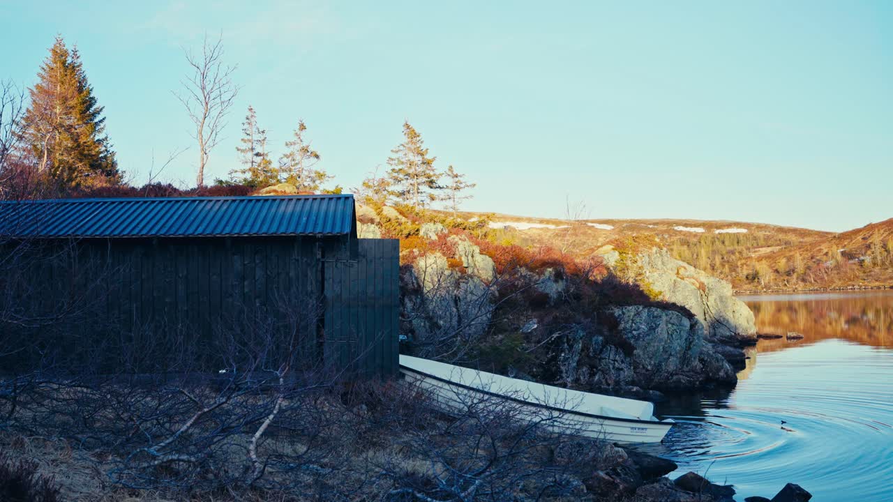 A Man is Launching a White Boat Into the Waters of Lake Reinsjøen in Åfjord, Trøndelag, Norway - Static Shot