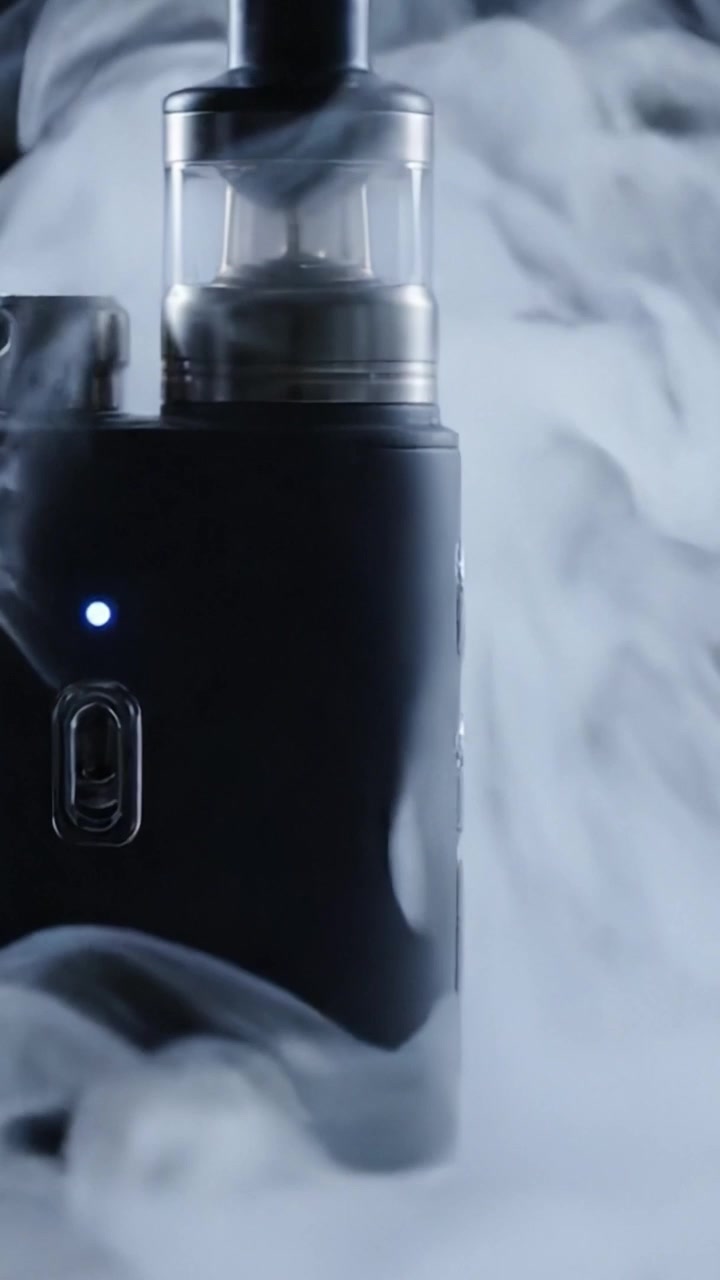 Captivating Close-Up of an Exquisite Vaporizer Device Generating Wispy Clouds of Vape in a Mysterious Atmosphere with Modern Aesthetics