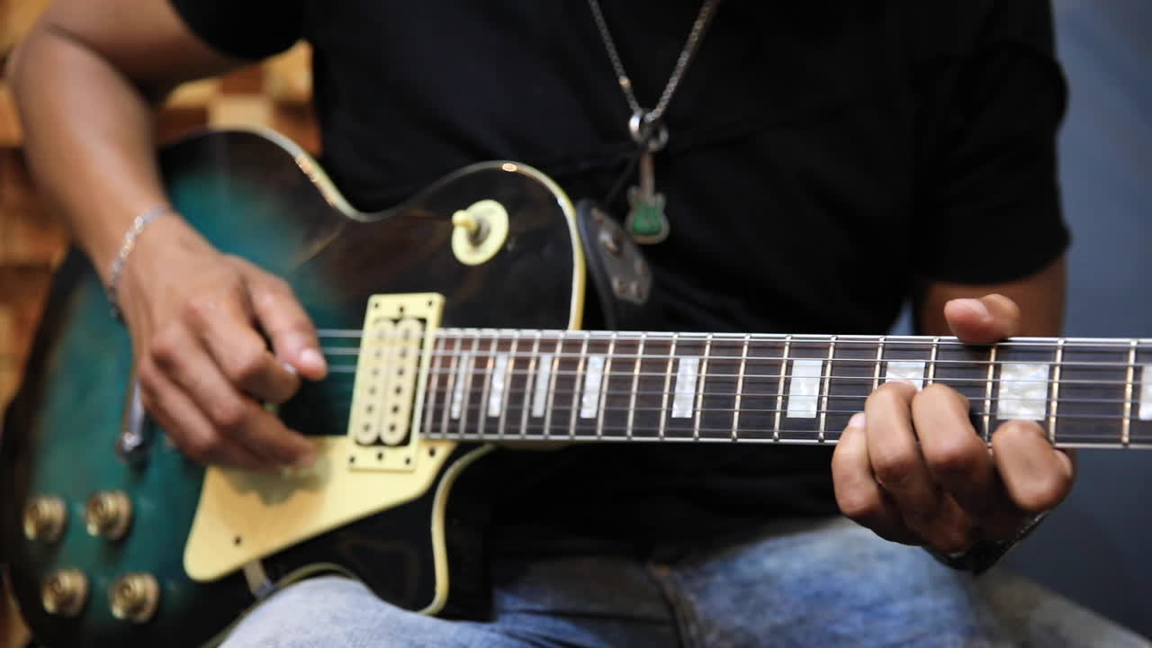 녹색 선버스트 레 폴 기타를 연주하는 녹음 스튜디오의 일렉트릭 기타리스트