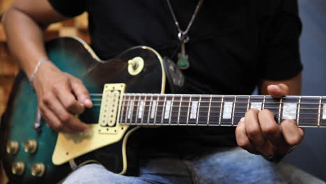guitarrista eléctrico en el estudio de grabación tocando una guitarra verde les paul sunburst