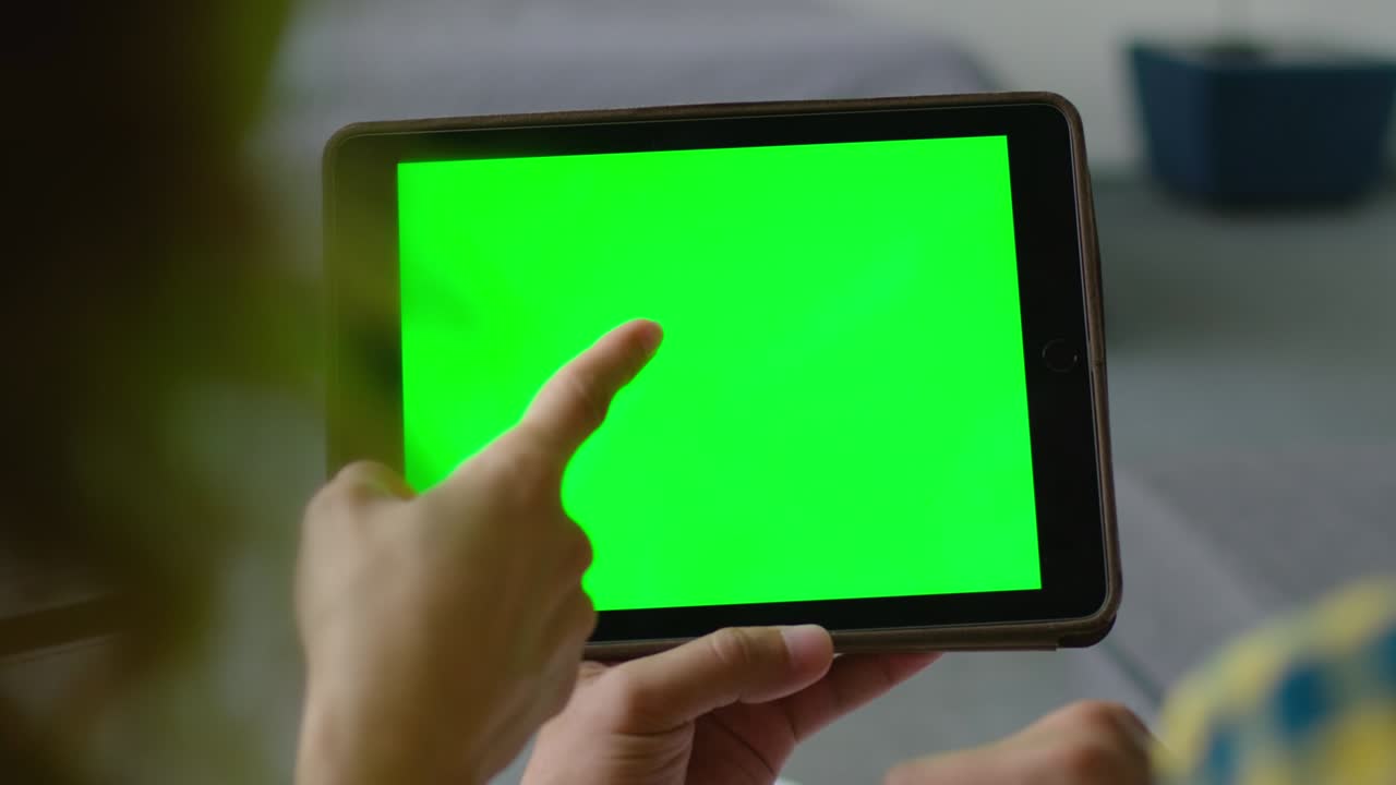 mujer y hombre usan una tableta con una pantalla verde para hacer una compra