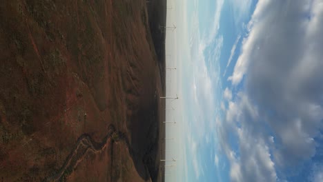 Vertical-Footage-Of-Wind-Farm-With-Wind-Turbines-Over-Hills-At-Sunset,-South-Australia