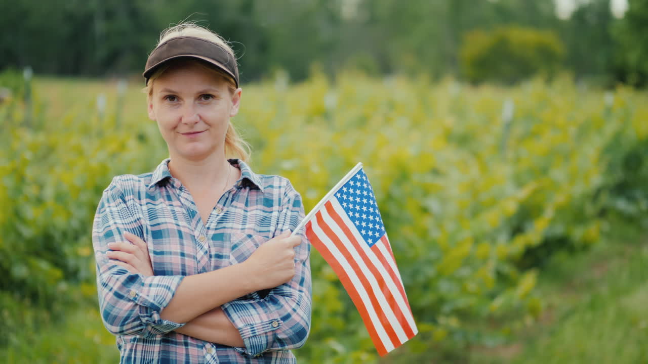mujer agricultora con bandera de estados unidos mirando a la cámara retrato de un agricultor estadounidense