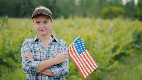 Bäuerin-Mit-USA-Flagge,-Die-Das-Kameraporträt-Eines-Amerikanischen-Landwirts-Betrachtet