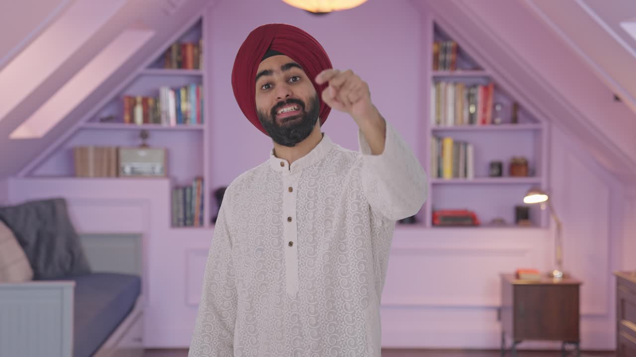 Uomo indiano Sikh felice che indica e chiama qualcuno