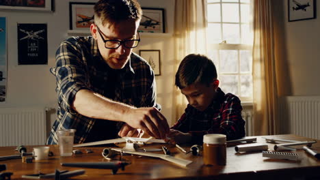father and son building a model airplane