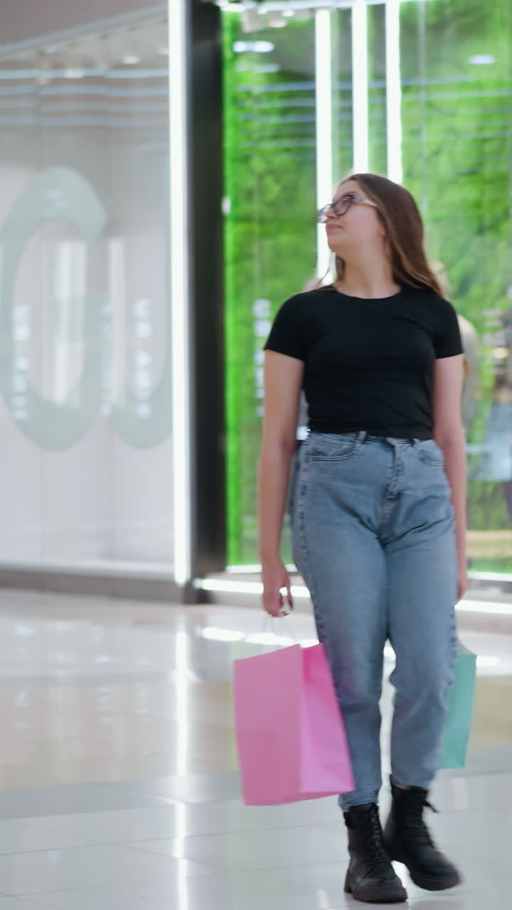 화려한 옷을 입고 쇼핑몰을 고 있는 자신감 넘치는 여성, 배경에는 화려한 상점 표지판이 있고, 활기찬 소매 분위기와 소비자의 쇼핑 행동을 반영합니다.