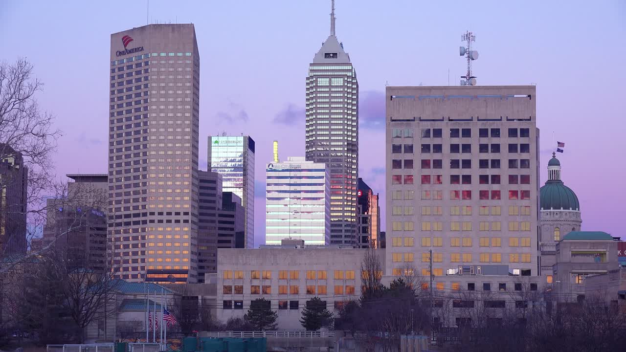 황혼에 인디애나폴리스 인디애나 스카이라인과 스테이트하우스 캐피탈 빌딩이 보입니다.