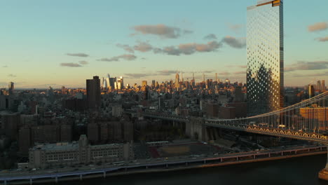 Sliding-revel-of-waterfront-with-busy-road.-Bridge,-high-rise-building-with-glossy-facade-and-skyline-with-skyscrapers-in-background.-Manhattan,-New-York-City,-USA