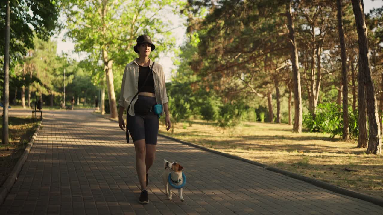 mujer paseando a su perro en el parque