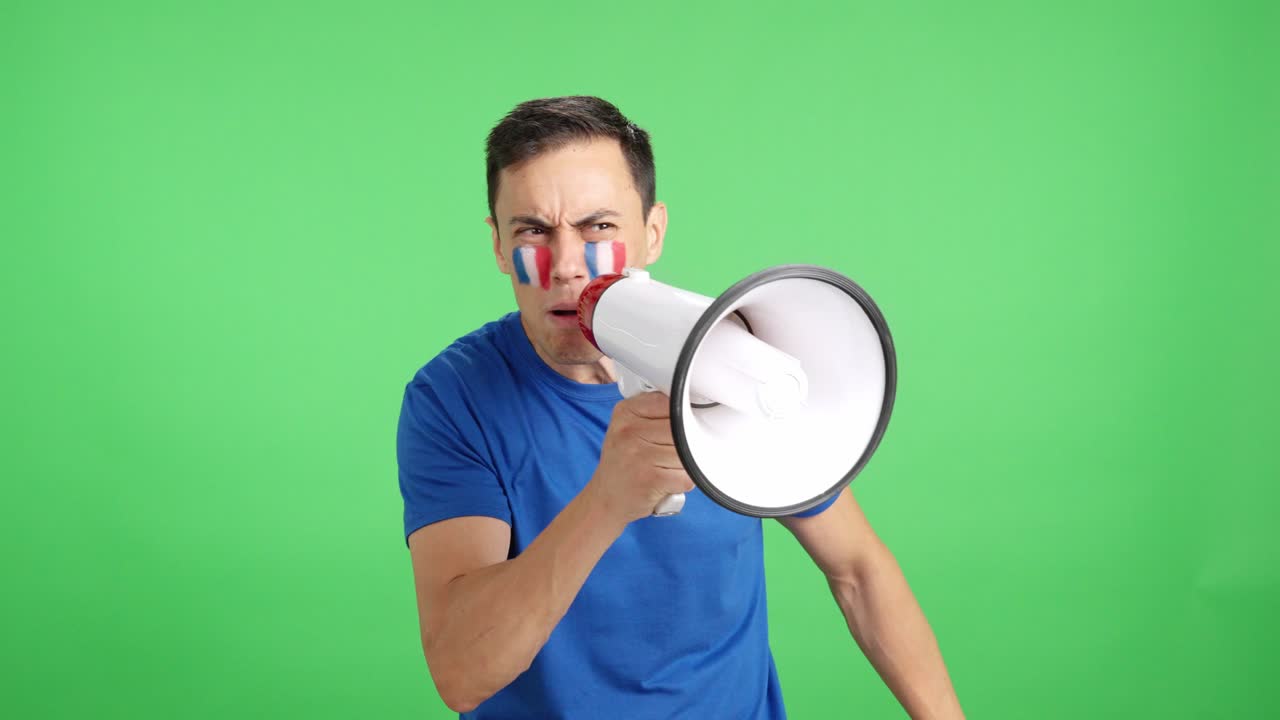 Excited man with french flag on face using a megaphone