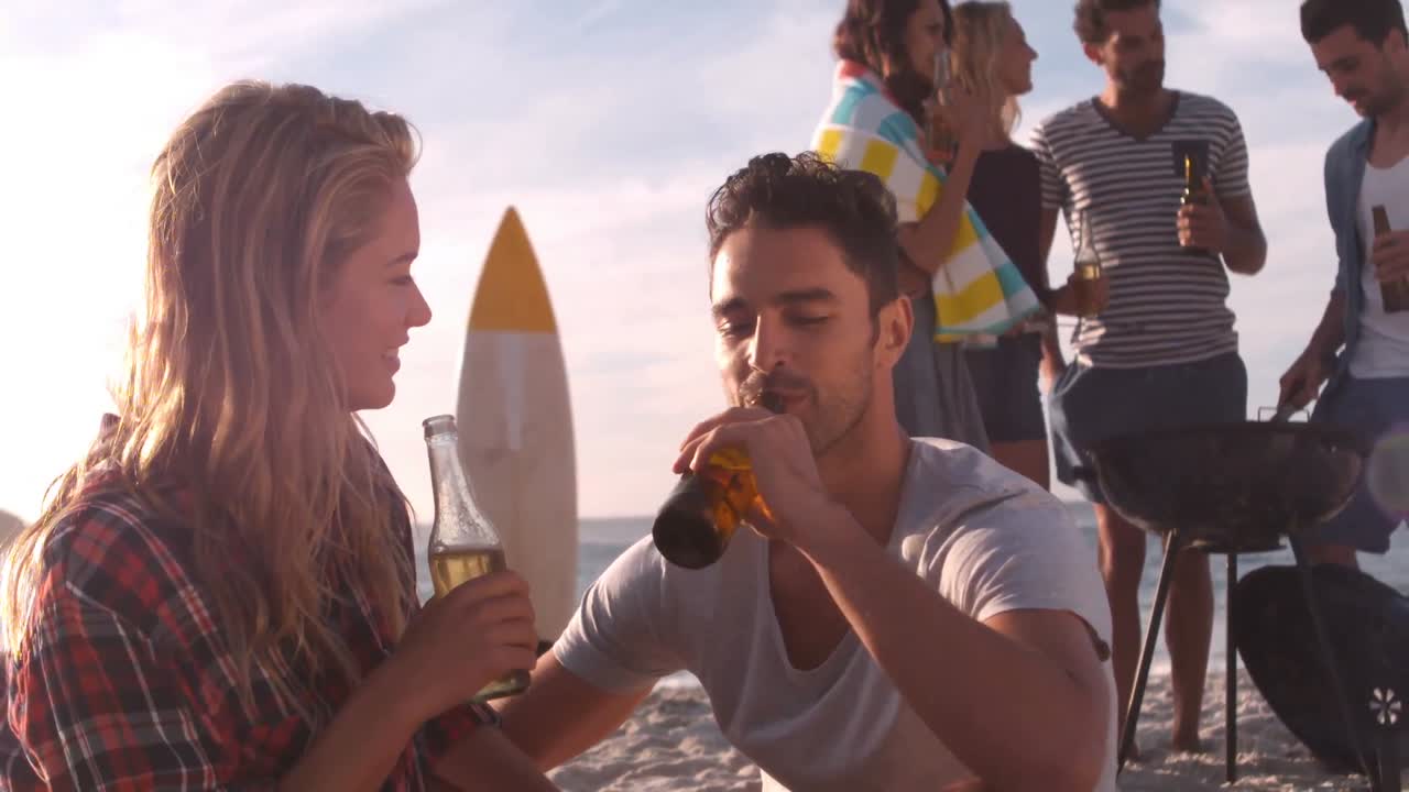 pareja bebiendo una cerveza en la playa