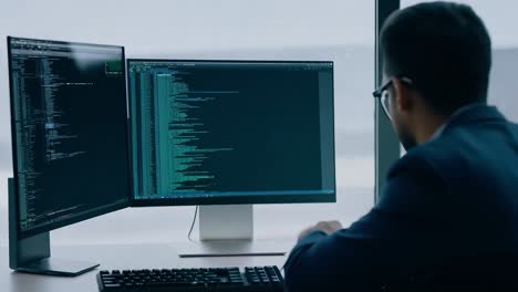 hombre codificando en su computadora en una oficina