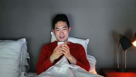 man using mobile phone on bed 4k