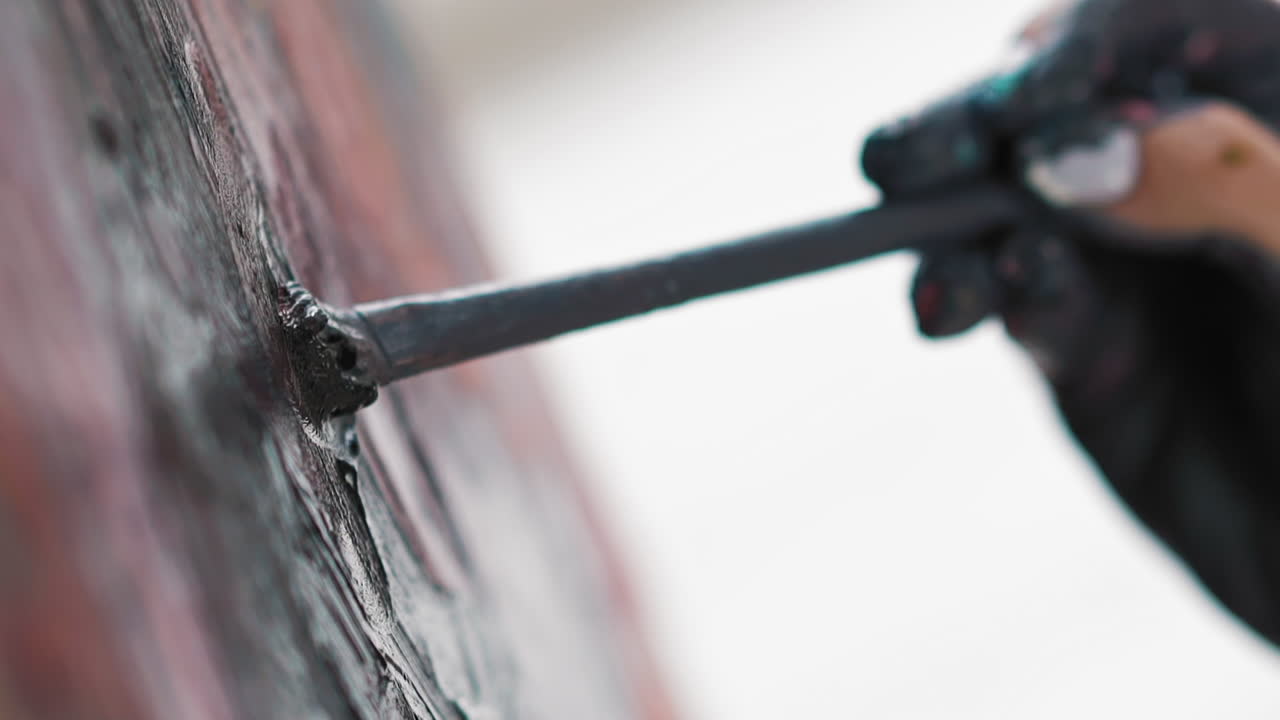 더러운 여성의 손은 캔버스에 스미어를 만드는 그림을 그립니다.