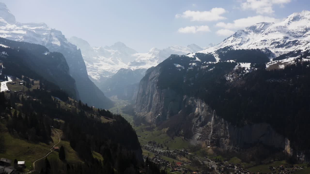 la antena vuela desde lo alto de wengen y muestra la ciudad de lauterbrunnen desde la distancia, suiza