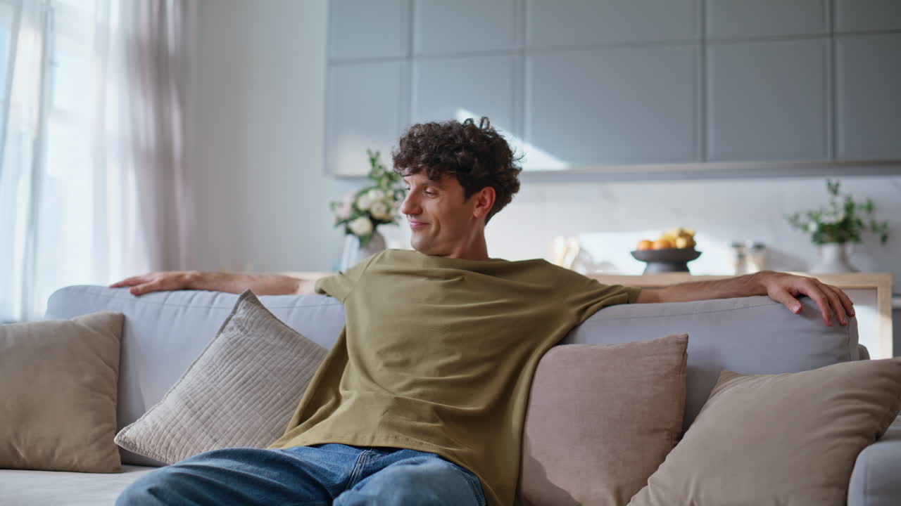 Relaxed hipster falling sofa feeling relaxed in room closeup. Man relaxing home