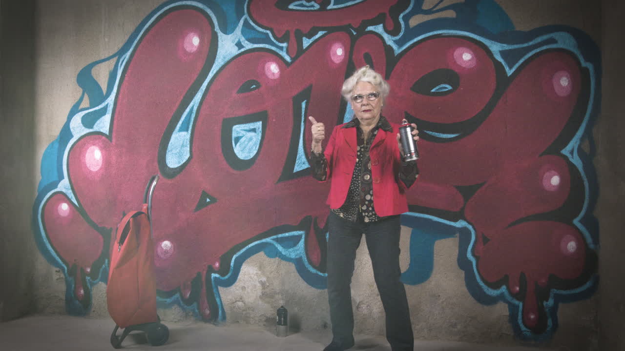 abuela rebelde artista de graffiti contra una pared urbana