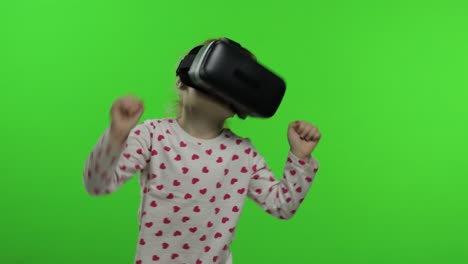 child girl using vr headset helmet to play game. watching virtual reality 3d 360 video. dancing