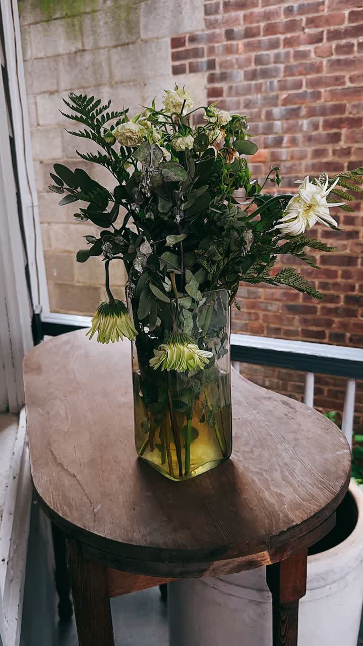 flores desvanecidas en un jarrón en una mesa de madera