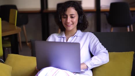 Portrait-Of-Curly,-Brunette-Woman-Working-On-Laptop-At-Home-Office