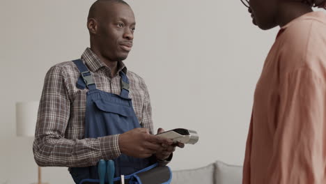 African Woman Paying to Carpenter with NFC Technology