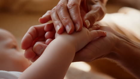 adult's hands gently holding a baby's hand, symbolizing care and connection