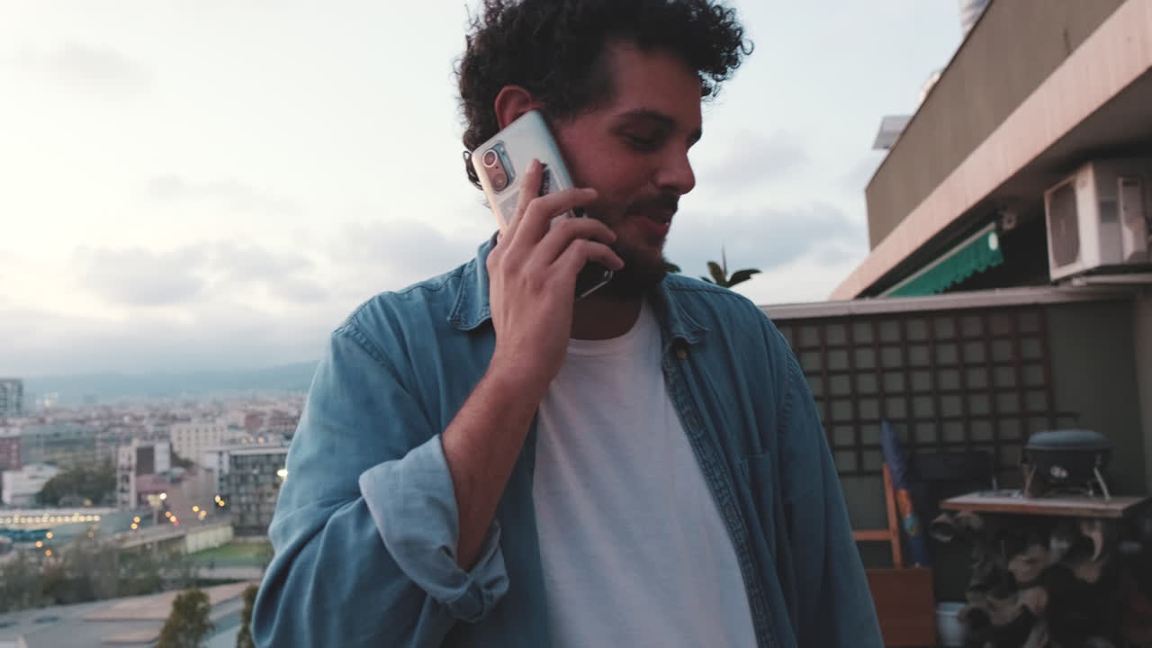 Man talking on the phone on a rooftop with city view