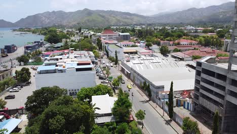 aerial drone rising over the busy capital city with traffic, buildings and landscape in dili, timor leste, southeast asia