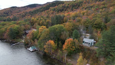 Vista-Aérea-De-La-Pintoresca-Costa-Del-Lago-Sunapee,-Colorido-Paisaje-Otoñal,-Casas-Forestales-En-La-Orilla-Del-Lago-Y-La-Carretera-Rural,-New-Hampshire-Usa,-Tiro-Con-Drones