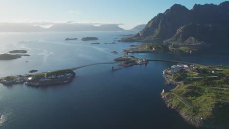 Fantastic-aerial-view-over-the-city-and-the-Henningsvaer-bridge-with-its-small-islands,-with-beautiful-sunset-colors