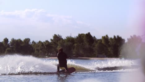 man wakeboarding on waves. water skiing on lake behind boat. wakeboarder surfing