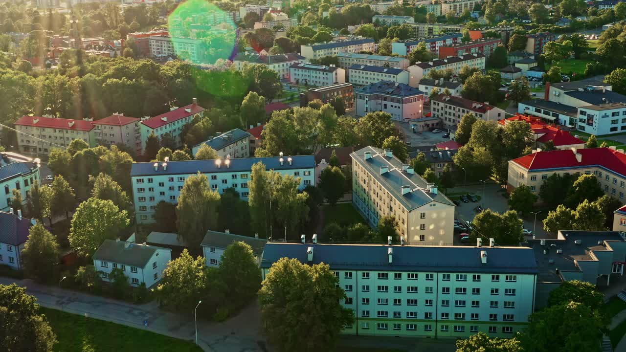 Aerial view of Valmiera city skyline at sunset with tree canopy and rooftops