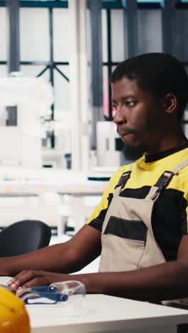 vertical video black engineer works on solar software settings in automated factory