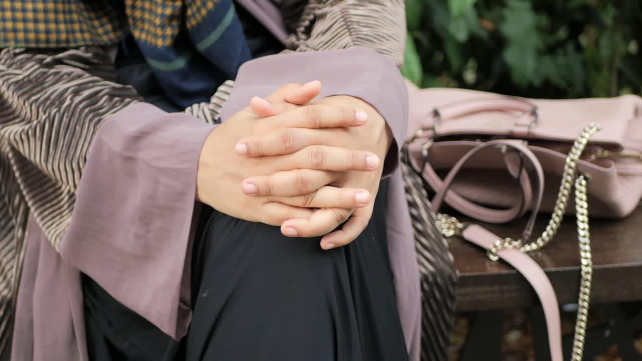 공원에 앉아 있는 사려 깊은 무슬림 여성들