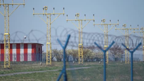 Landescheinwerfer-Des-Flughafens-Hinter-Dem-Maschendrahtzaun