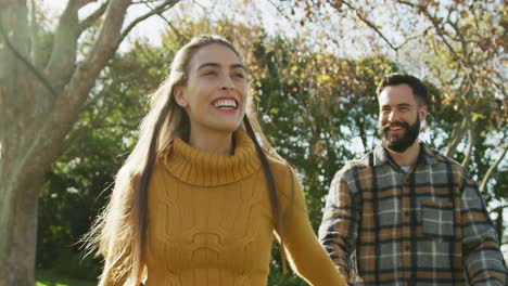 video de una feliz pareja caucásica vestida cálidamente en el jardín